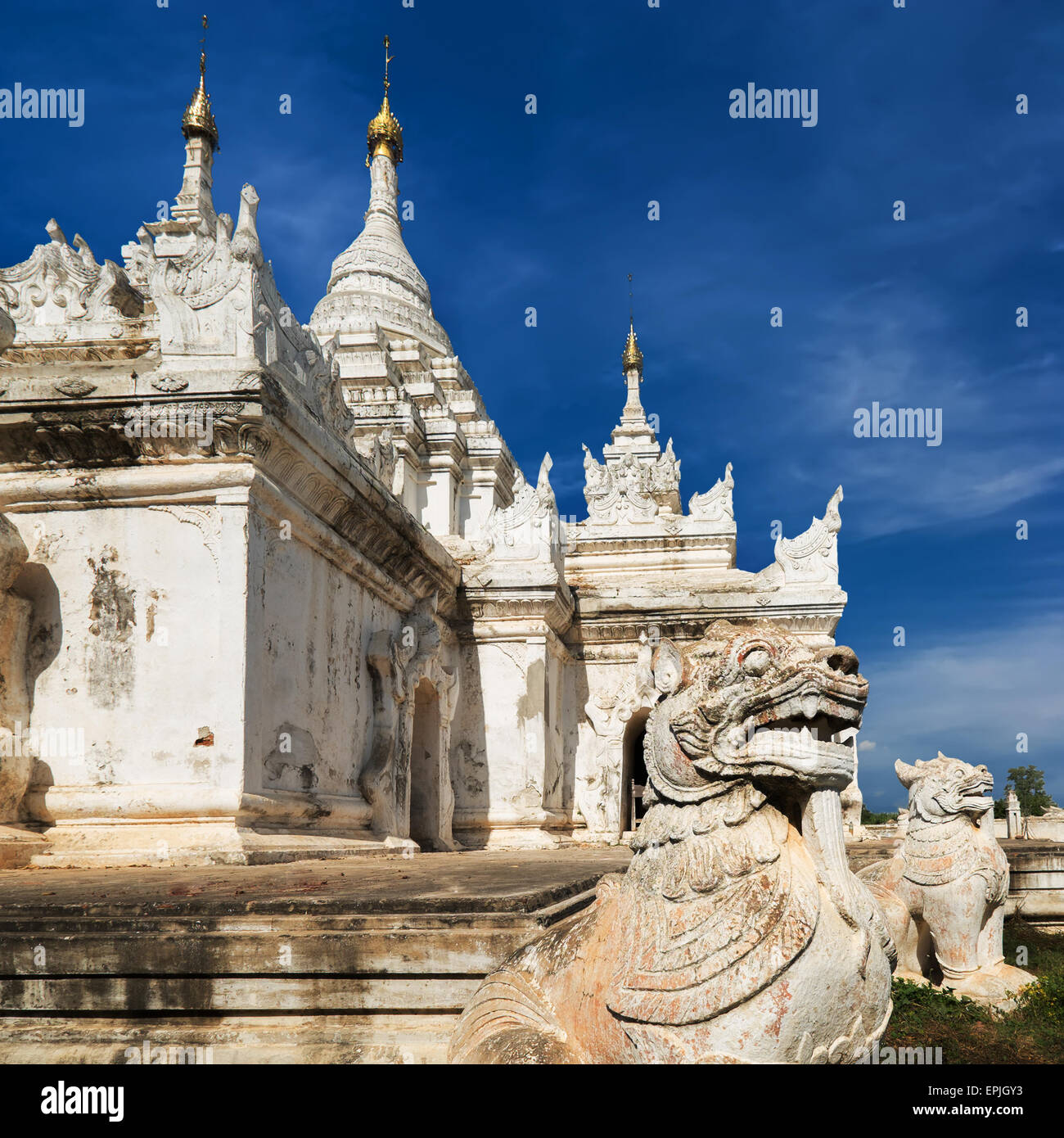 Weiße Pagode am Inwa alte Stadt mit Löwen-Wächter-Statuen. Beeindruckende Architektur der alten buddhistischen Tempel. Myanmar (Burma) tra Stockfoto