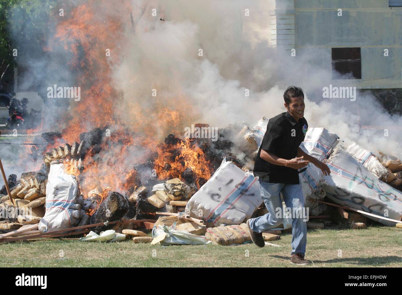 Aceh, Indonesien. 19. Mai 2015. Ein indonesische Anti-Drogen-Offizier reagiert wie die beschlagnahmten Drogen brennt in Aceh, Indonesien, am 19. Mai 2015. Indonesische Anti-Drogen-Polizisten zerstört 11,6 Tonnen Marihuana und 91 Hektar Marihuana-Feld, auch 4 Verdächtigen in einer Anti-Drogen-Operation von Januar bis Mai dieses Jahres festgehalten. Bildnachweis: Junaidi/Xinhua/Alamy Live-Nachrichten Stockfoto