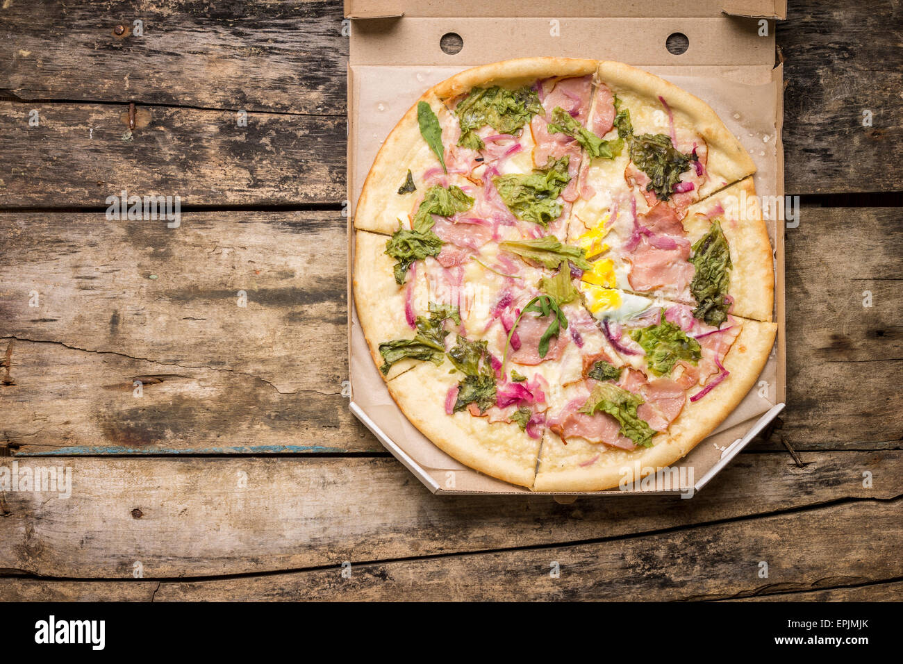 Restaurant Menü und Rezept Hintergrund. Gourmet-Pizza in Box auf Holztisch mit Textfreiraum Stockfoto