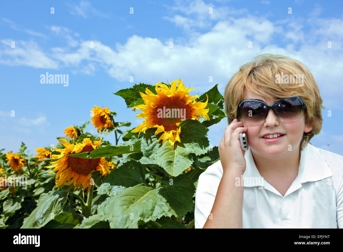 Thel blonden Jungen reden über Handy Stockfoto