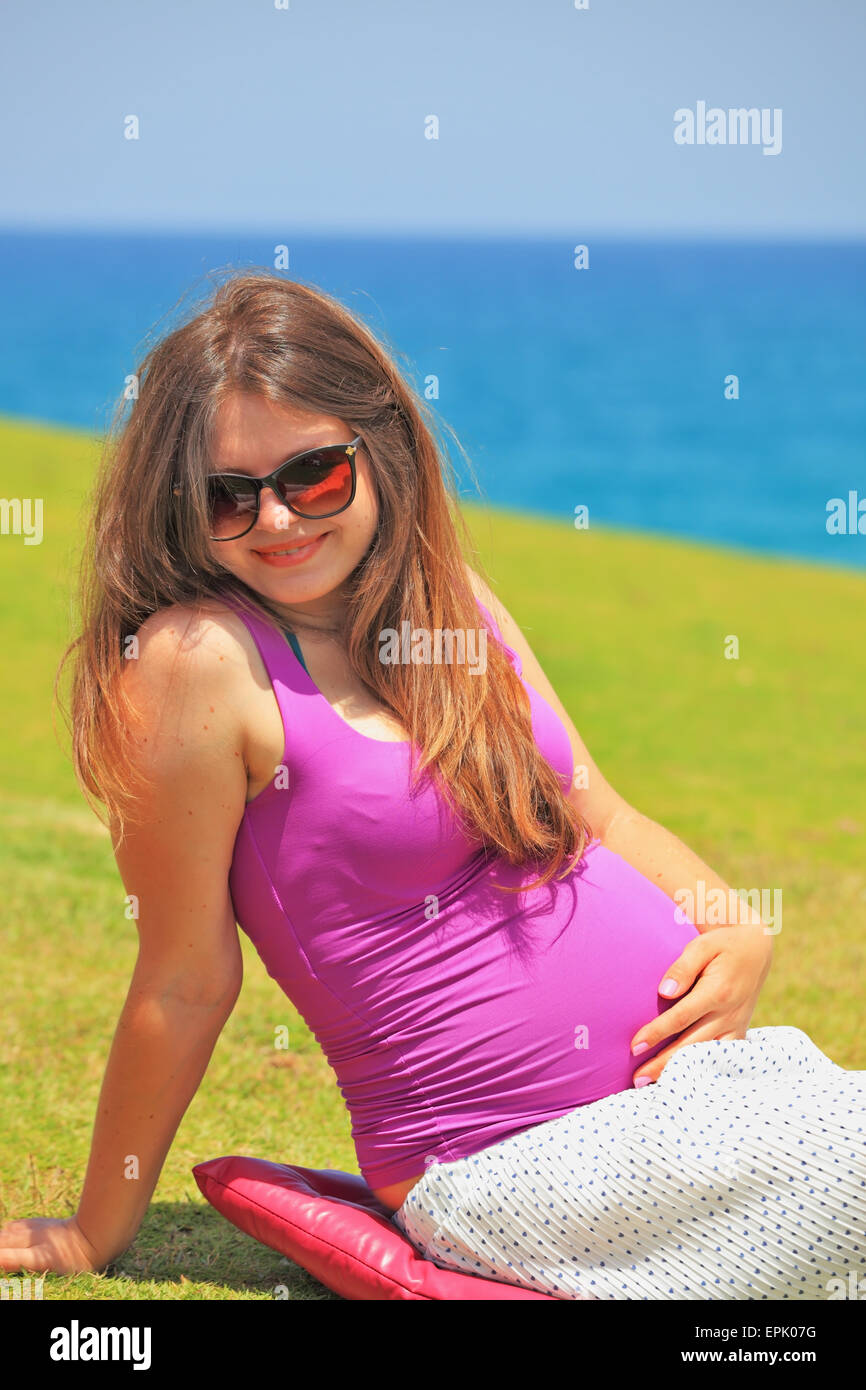 Hübsche junge schwangere Frau ist entspannend Stockfoto