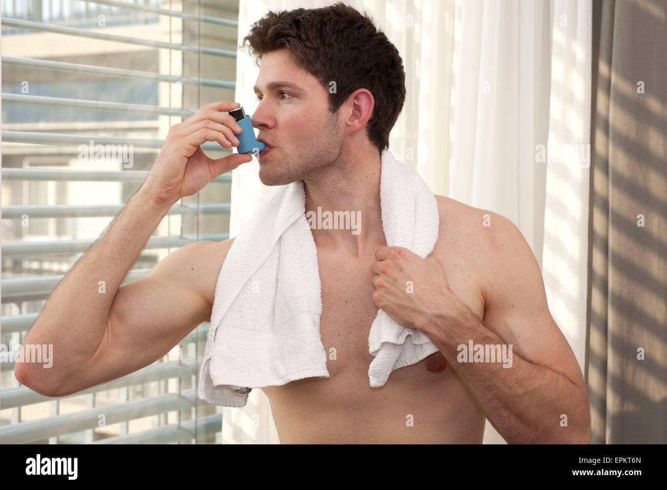 Junger Mann mit Asthma-Inhalator Stockfoto