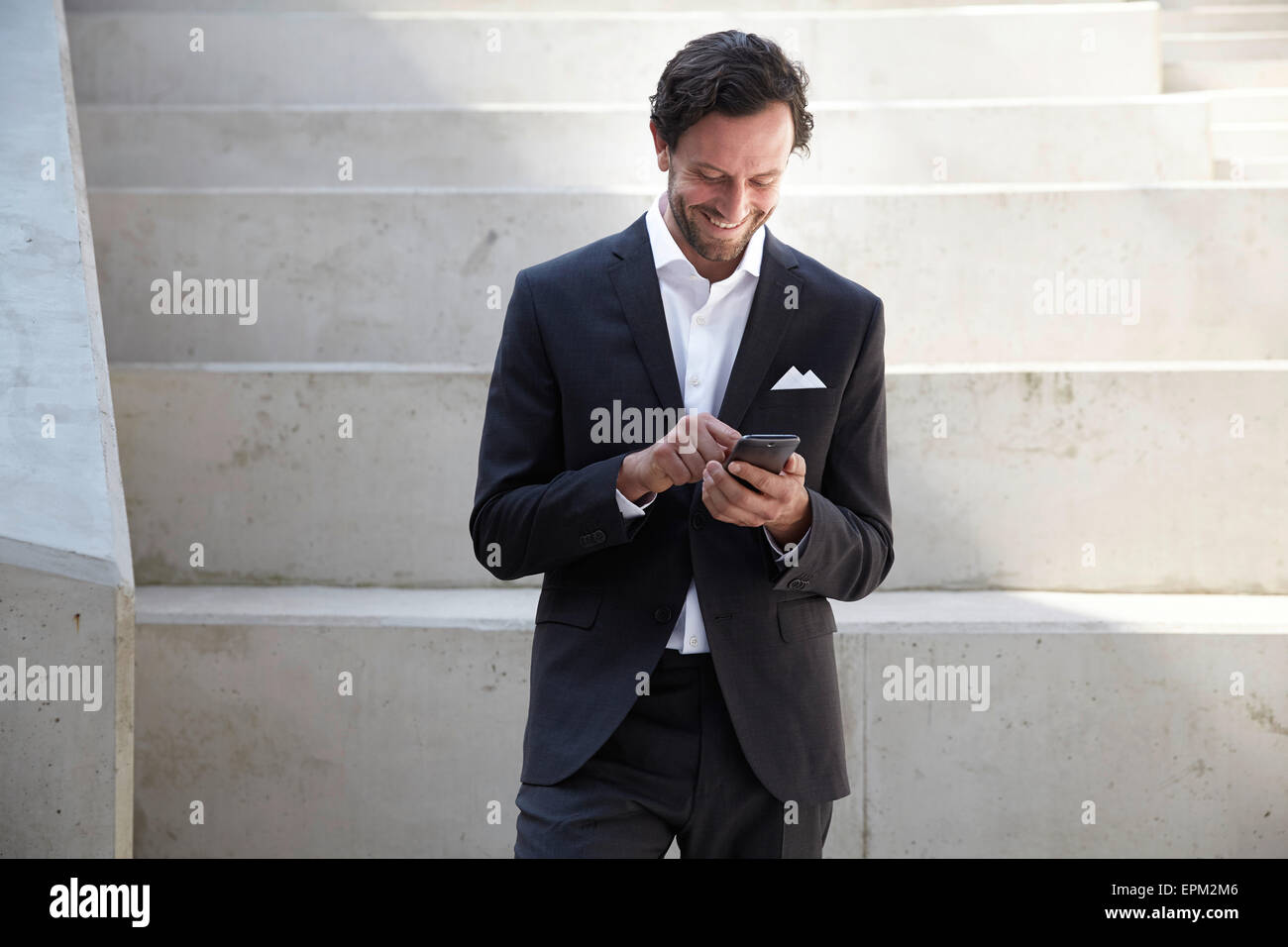 Geschäftsmann mit Smartphone in einem modernen Gebäude Stockfoto