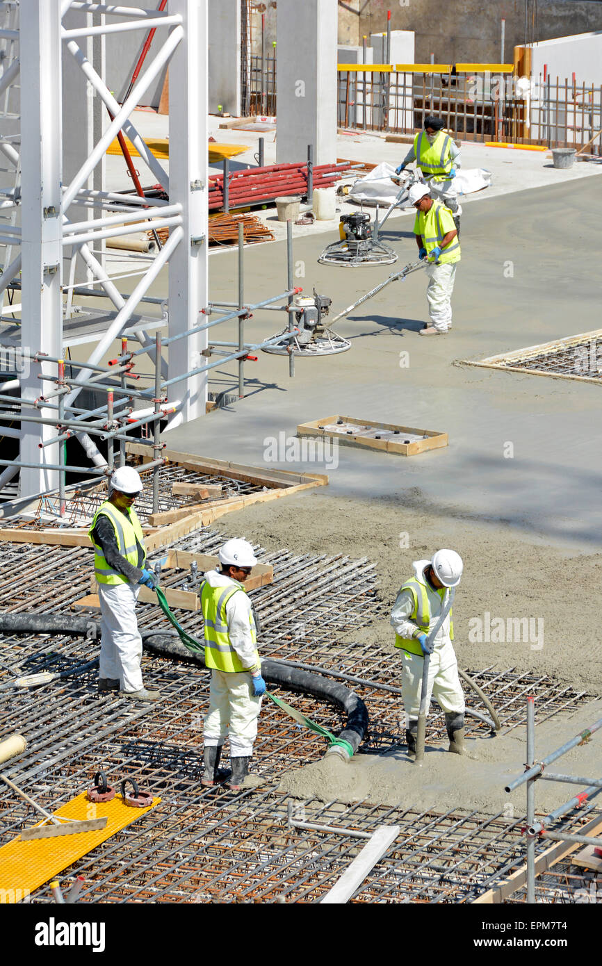 Bauindustrie Ort & vibrieren gepumpten Beton in die Verstärkung mit Power Float Arbeiter Fertigstellung glatte Bodenplatte London UK Stockfoto