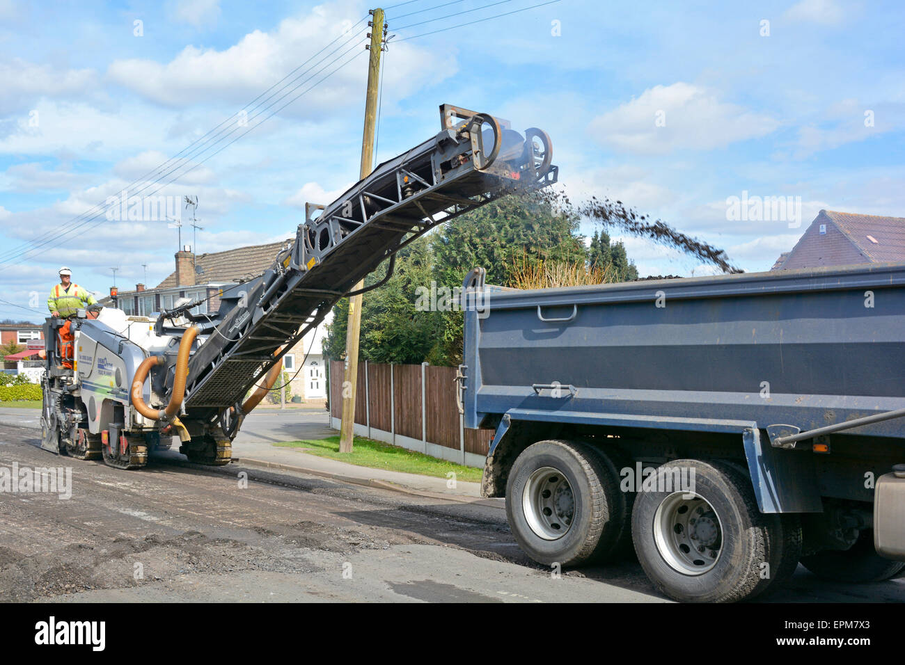 Wartung Straßenarbeiten Kipper LKW Beladung mit abgenutzten Asphalt Oberfläche durch Hobeln Maschinentreiber für die Sanierung und Reparaturen Essex England UK entfernt Stockfoto