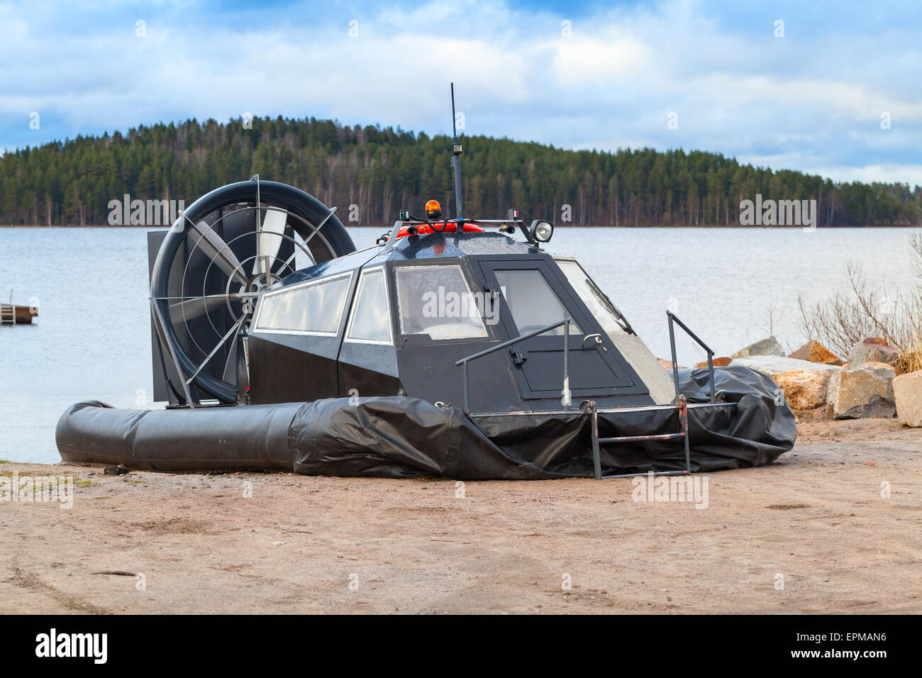 Schwarze moderne Hovercraft legt auf der sandigen Küste Saimaa See in Finnland Stockfoto