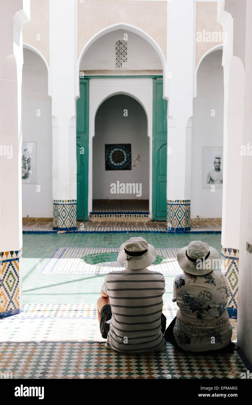 A paar Touristen, die Ruhe in einem Innenhof des Musee de Marrakesch im Ruhestand und die Umgebung zu genießen. Stockfoto