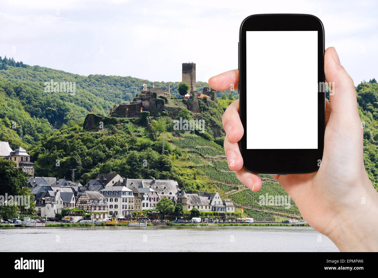 Reisekonzept - Feriendorf Foto Beilstein und Burg Metternich, Deutschland am Smartphone mit ausgeschnittenen Bildschirm mit blan Stockfoto