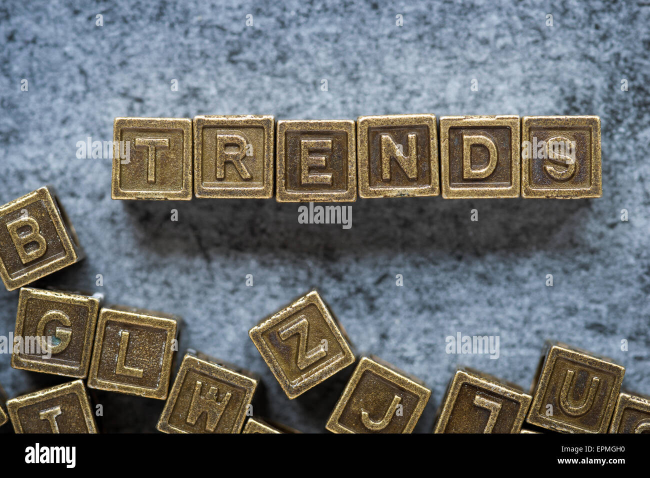 Trends-Wort zusammengesetzt aus metallischen Blöcken über Grunge Hintergrund Stockfoto