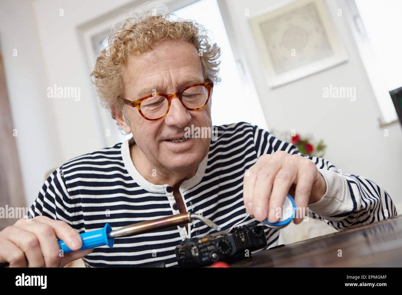 Senior woman Löten defekte Kamera Stockfoto