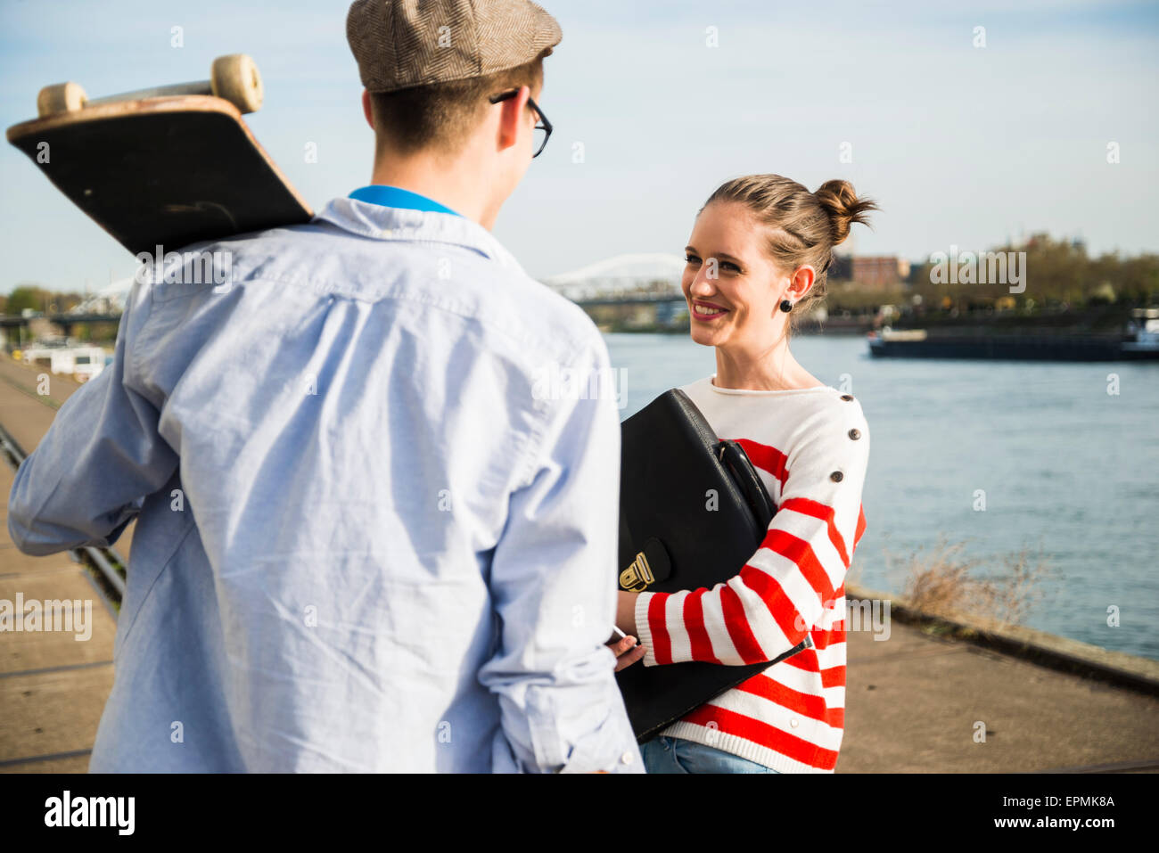 Jungen Mann und Frau im Gespräch am Flussufer Stockfoto