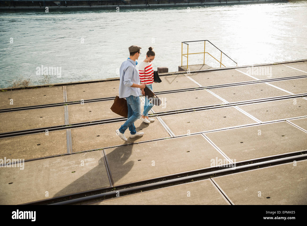 Junger Mann und Frau zu Fuß in der Spur am Flussufer Stockfoto