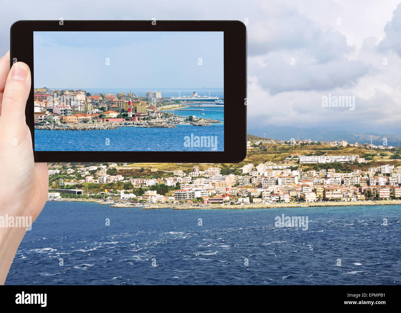 Reisen Sie Konzept - Tourist schnappen Foto Stadt Reggio Di Calabria von Straße von Messina, Kalabrien, Italien auf TabletPC Stockfoto