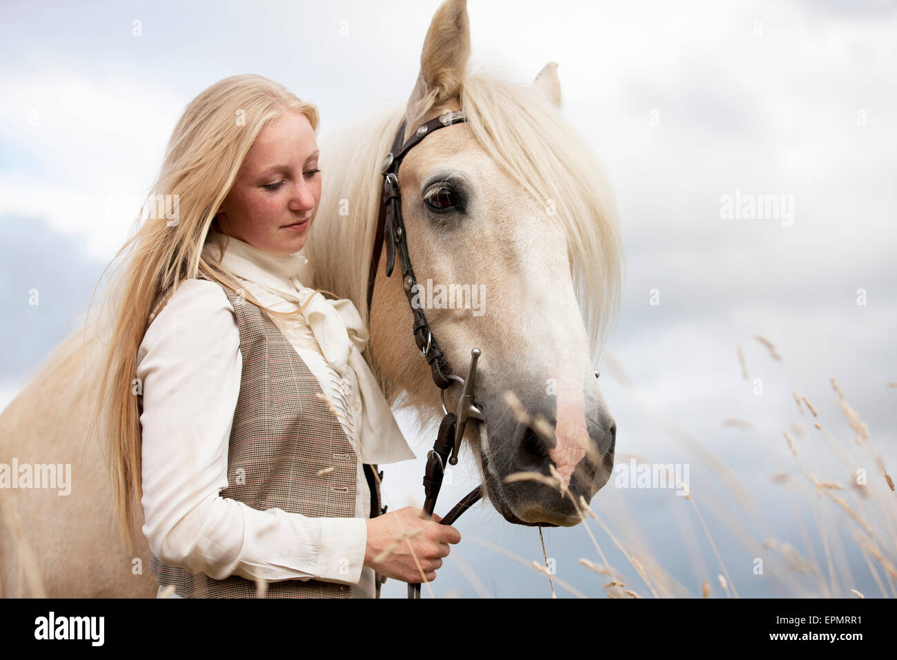Eine junge Frau mit einem Palomino-Pferd Stockfoto