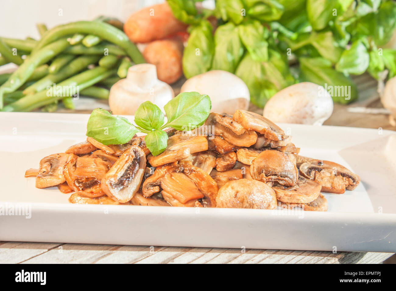 Gebratene Champignons Pilze auf einen weißen Tisch vor Gemüse Stockfoto