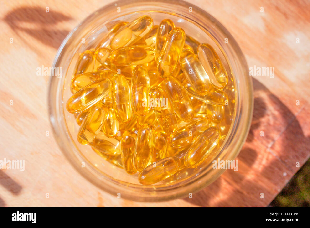 Omega-3 Kapseln in einem Glas können auf einem Holzbrett Stockfoto