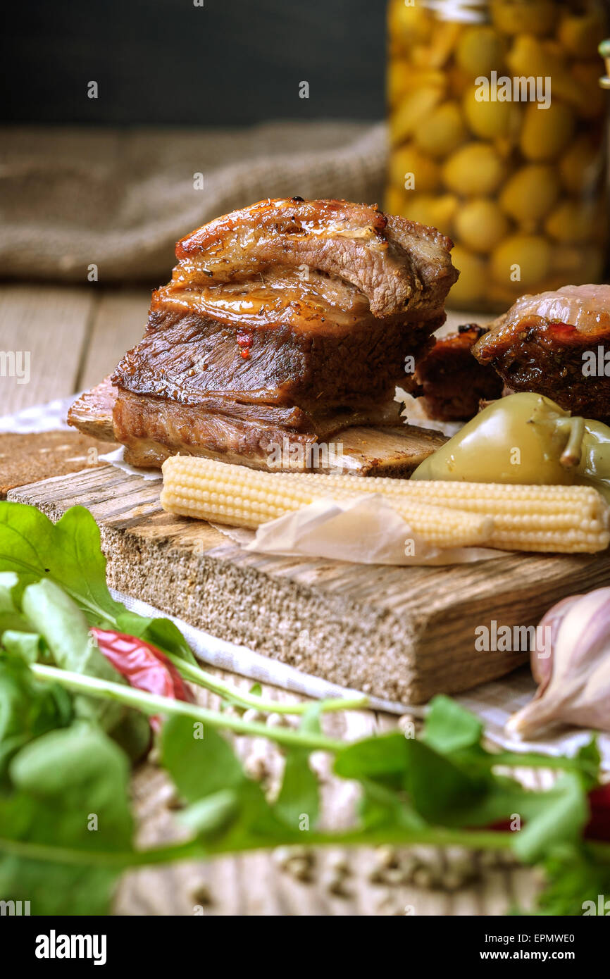 Spare Ribs mit Kräutern und Gewürzen gebacken. Hölzerne Hintergrund. Rustikalen Stil. Stockfoto