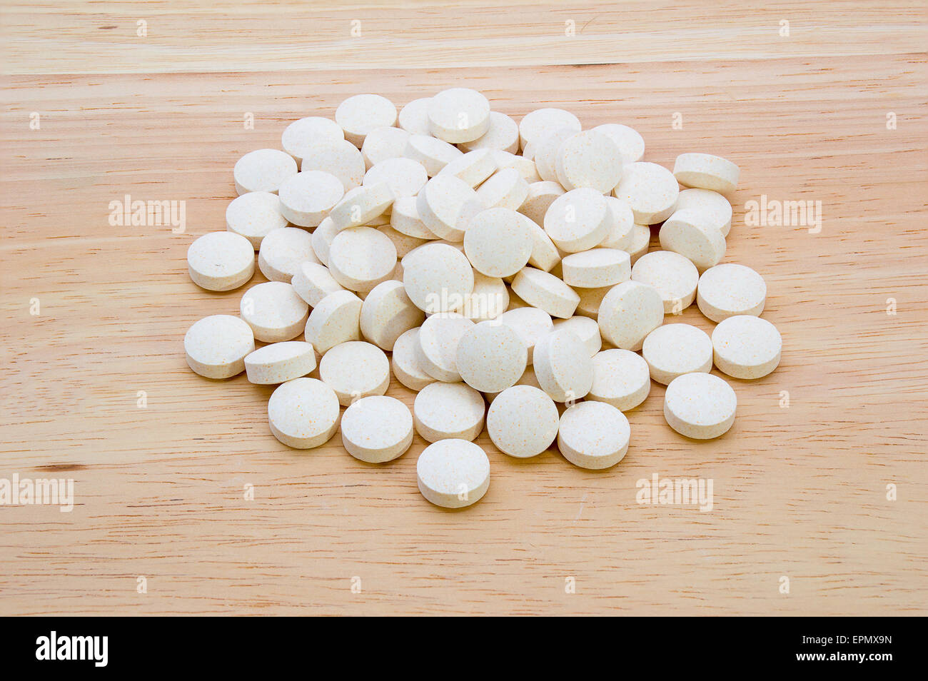 Ein Haufen von Vitamintabletten auf einem hölzernen Hintergrund Stockfoto