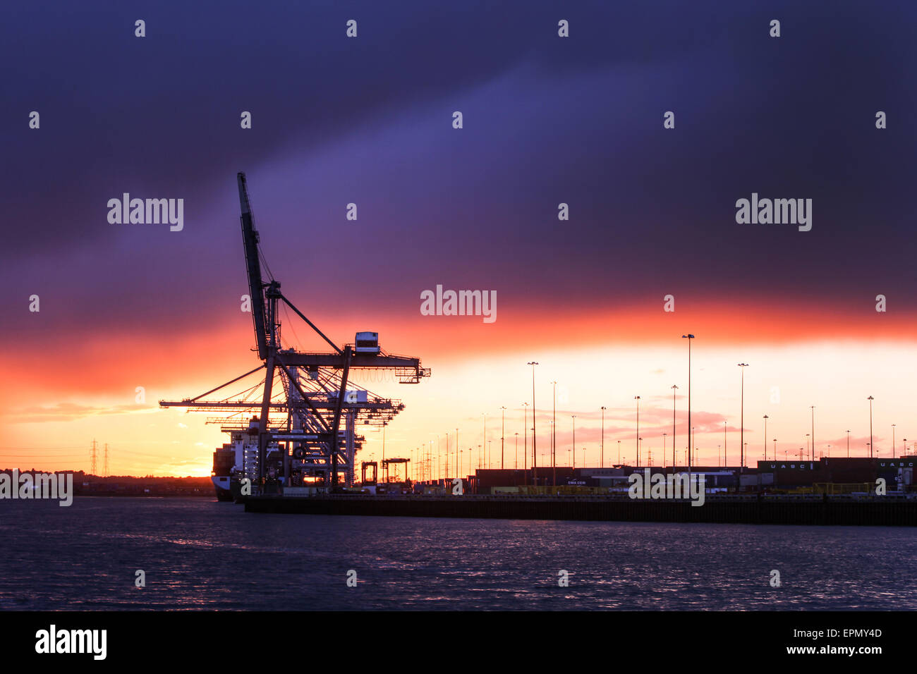 Gewitterwolken über die Container-Hafen Southampton Docks zu sammeln, wenn die Sonne untergeht Stockfoto