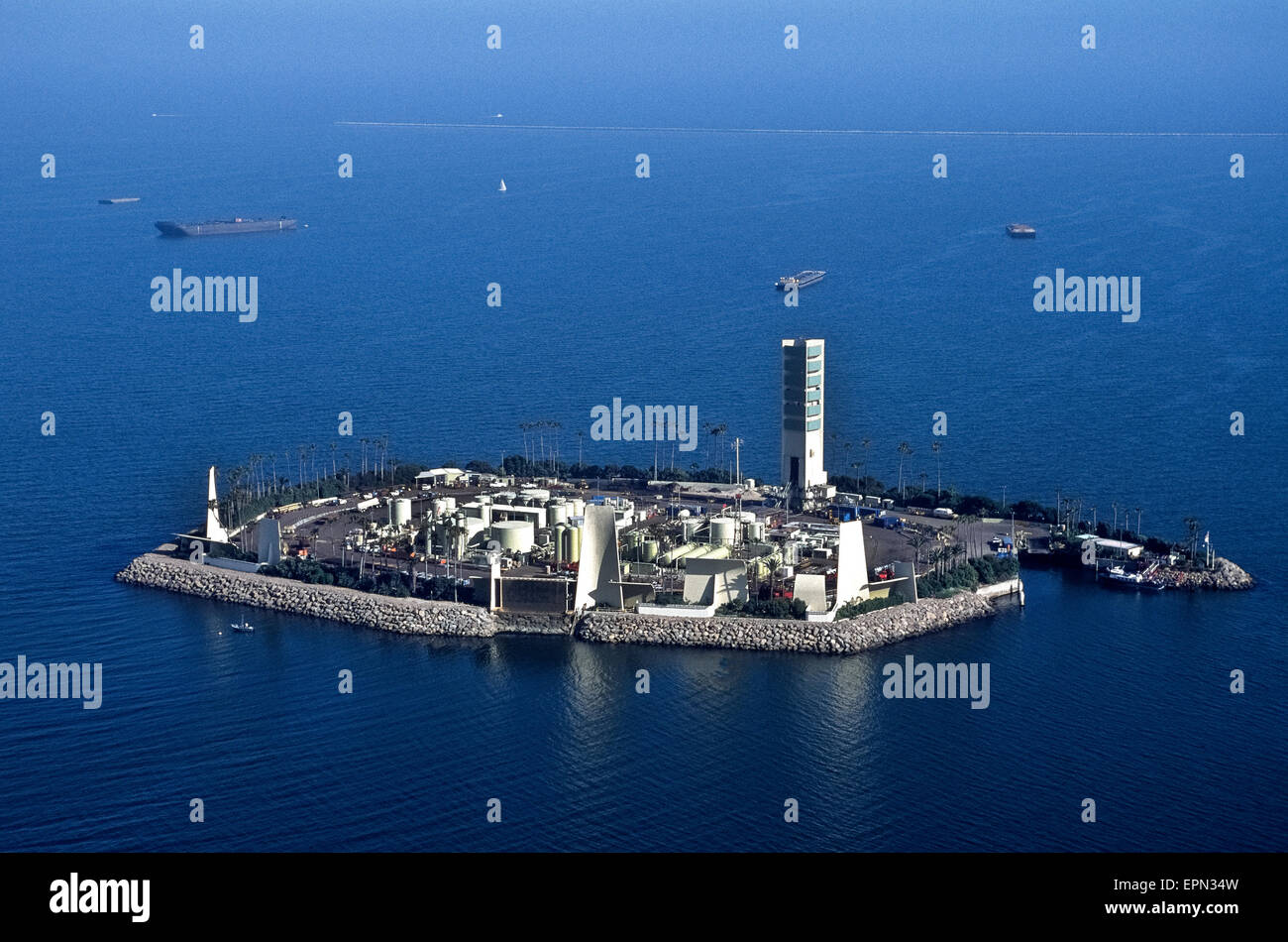Eine Luftaufnahme zeigt einen der vier künstlichen Inseln wo Ölquellen tätig sind direkt an der Küste in San Pedro Bucht in Sichtweite der Stadt von Long Beach, Kalifornien, USA. Die Neuheit ist, dass die Lagertanks, Bohrtürme, Pumpen und andere notwendige Ausrüstung für Rohöl unter dem Meer extrahieren getarnt und schallisoliert von tropischen Landschaftsgestaltung, Wasserfälle und Gebäudefassaden eine Insel-Resort wie gesehen von der Stadt Küste nachempfunden. Dies ist Insel weiß, benannt nach US-amerikanischer Astronaut Ed White, die umgekommen sind, wenn sein Raumschiff Apollo 1 gefangen im Jahr 1967 Feuer. Stockfoto
