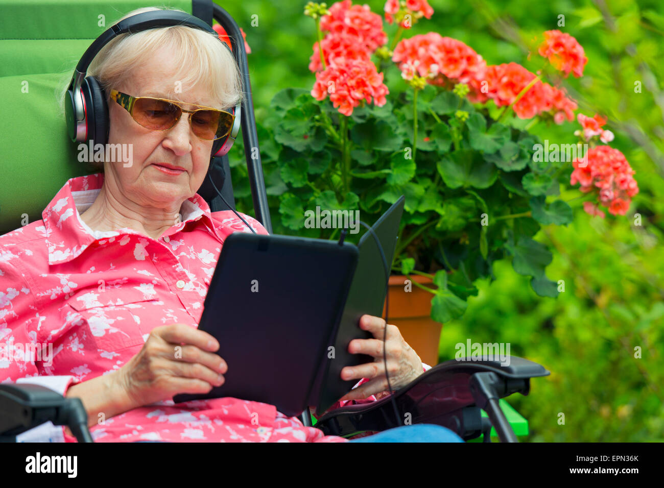 Frau trägt Kopfhörer Lesen Hörbücher Inhalte auf Tablet oder Kindle-Gerät,  eBook Reader Stockfotografie - Alamy