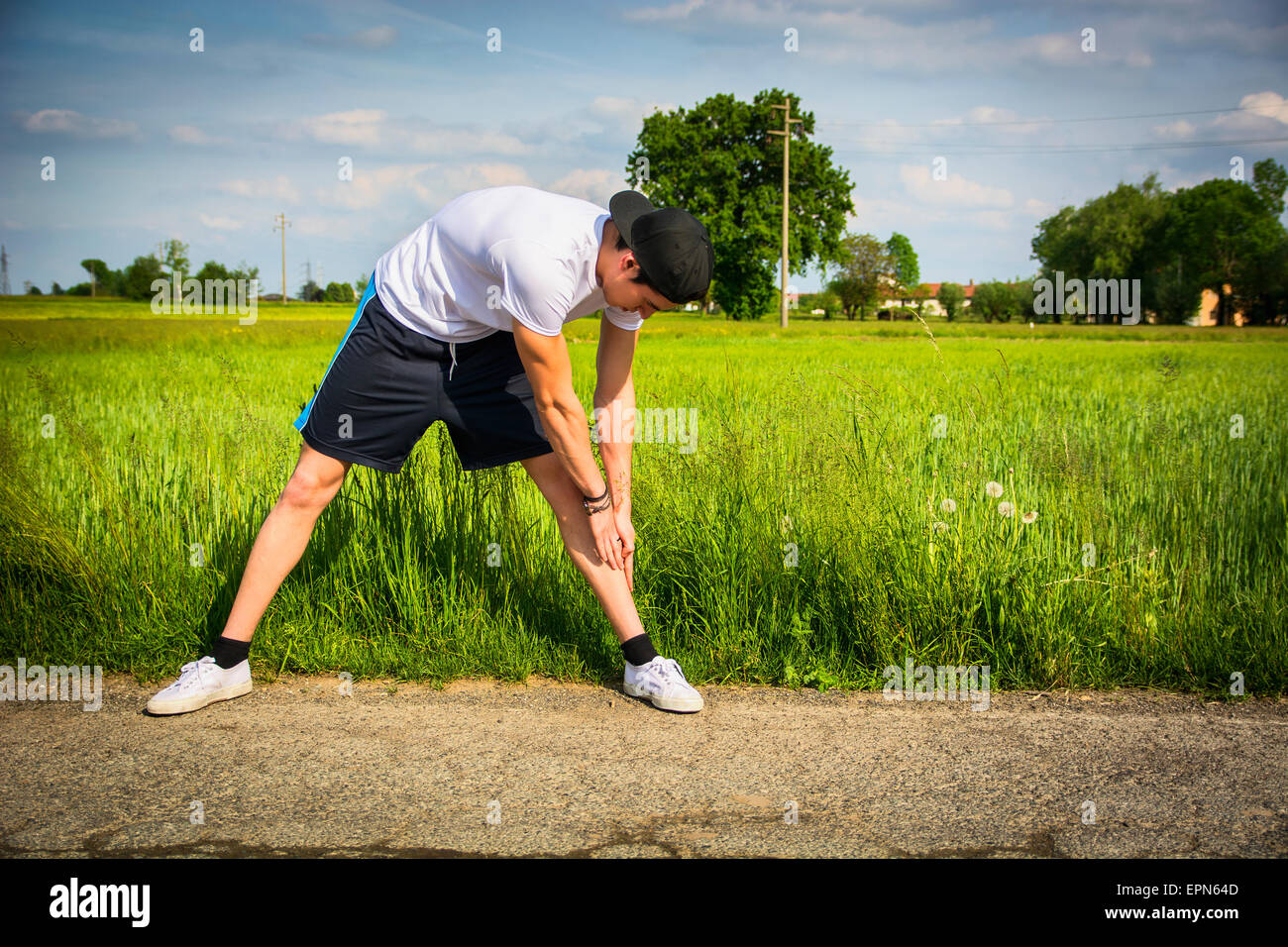 Sportlich, gut aussehend passen jungen Mann im Land, stretching-Übungen im freien Stockfoto