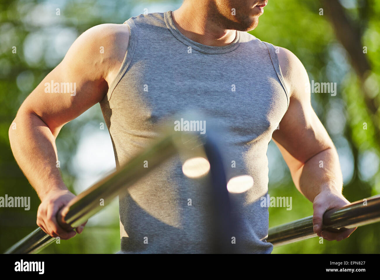 Aktiven Mann in graue Weste Übung für Arme im freien Stockfoto