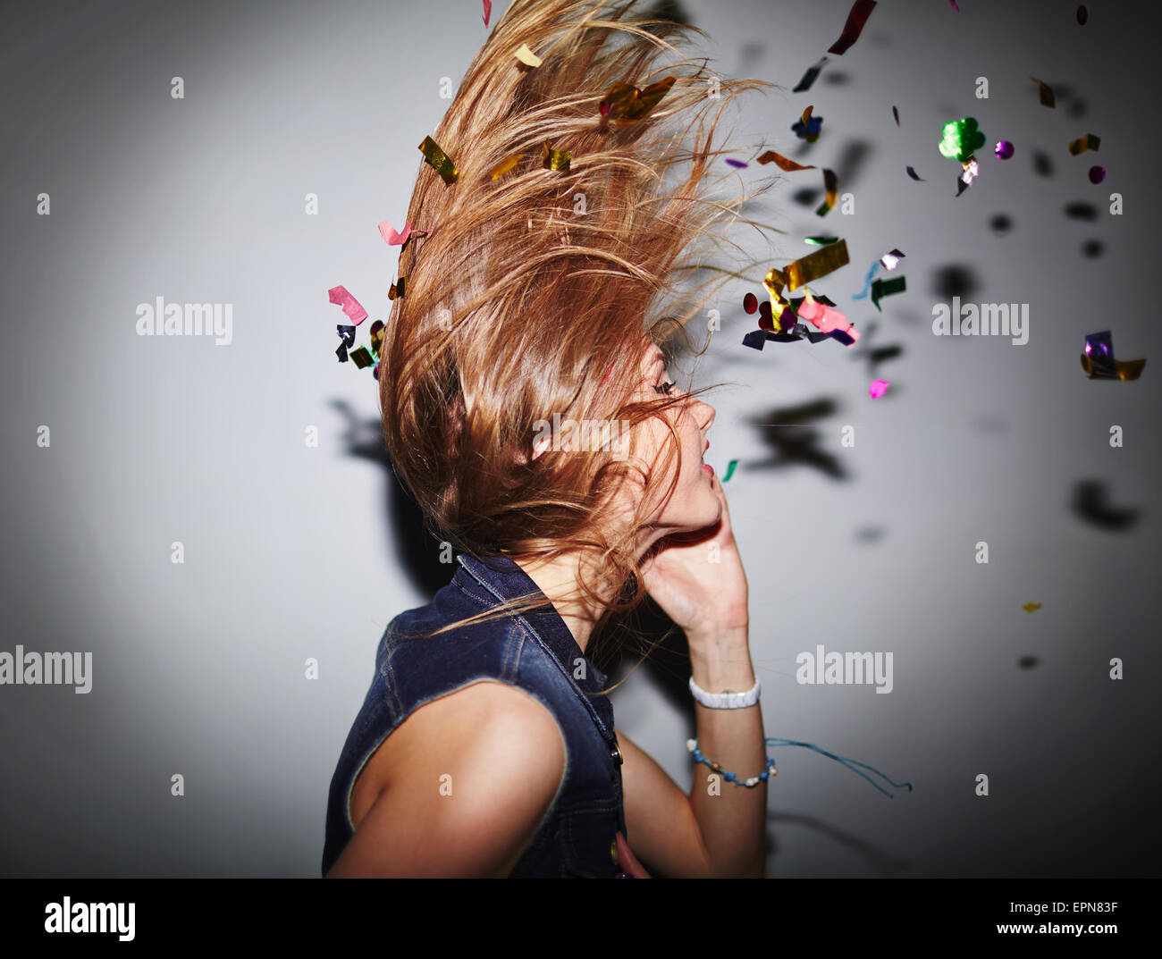 Energetische Tänzerin mit Konfetti Spaß im Nachtclub Stockfoto