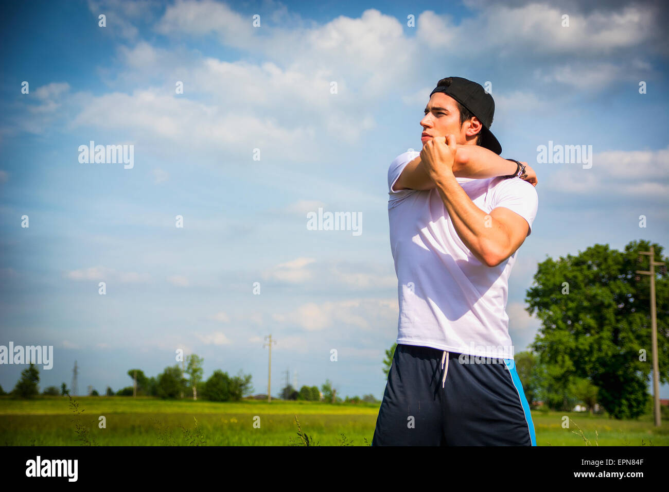 Sportlich, gut aussehend passen jungen Mann im Land, stretching-Übungen im freien Stockfoto