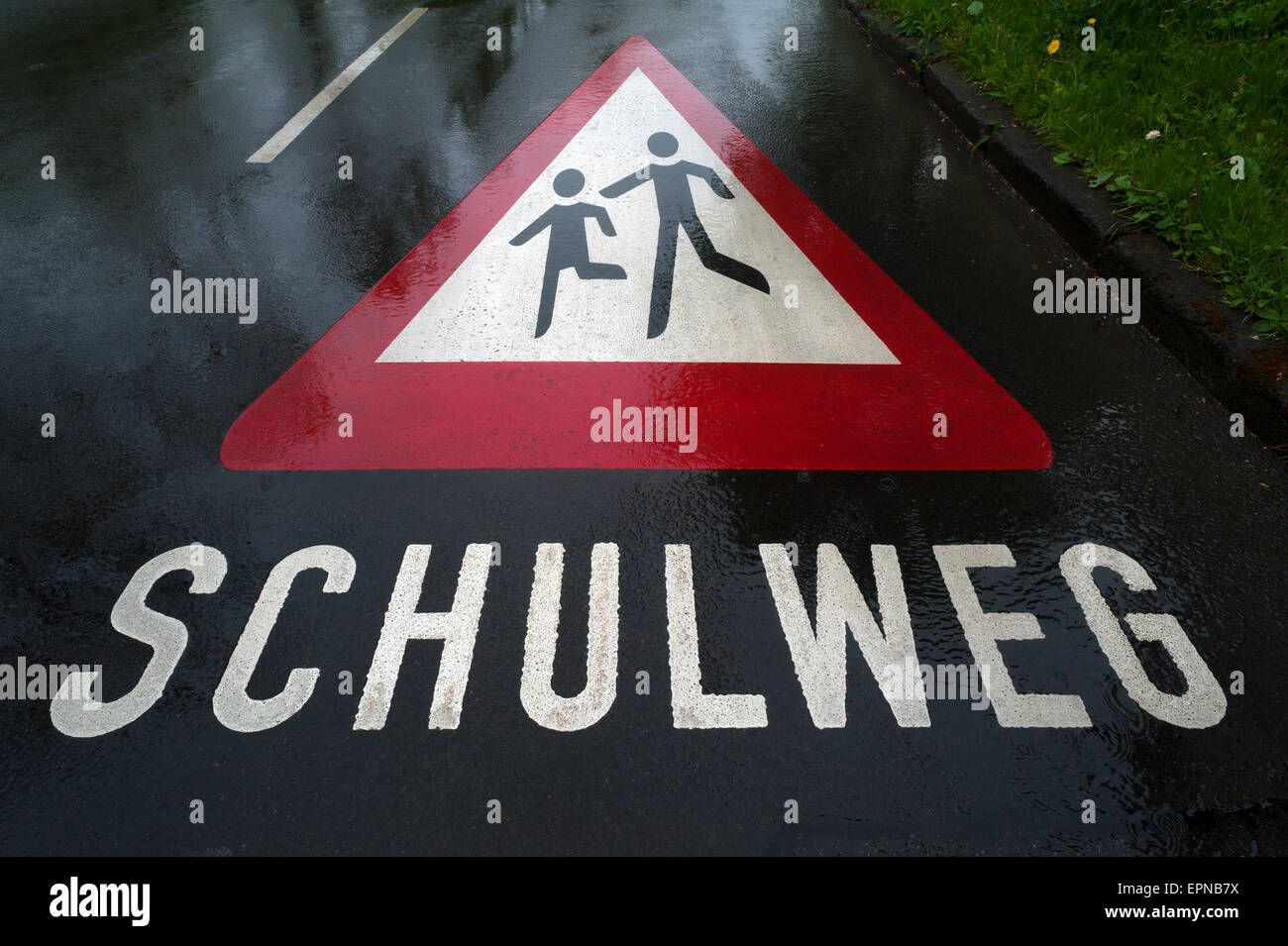 Schulweg, Schule Weg, Warnzeichen gemalt auf nasser Fahrbahn, auf Deutsch, Haßfurt, untere Franken, Bayern, Deutschland Stockfoto