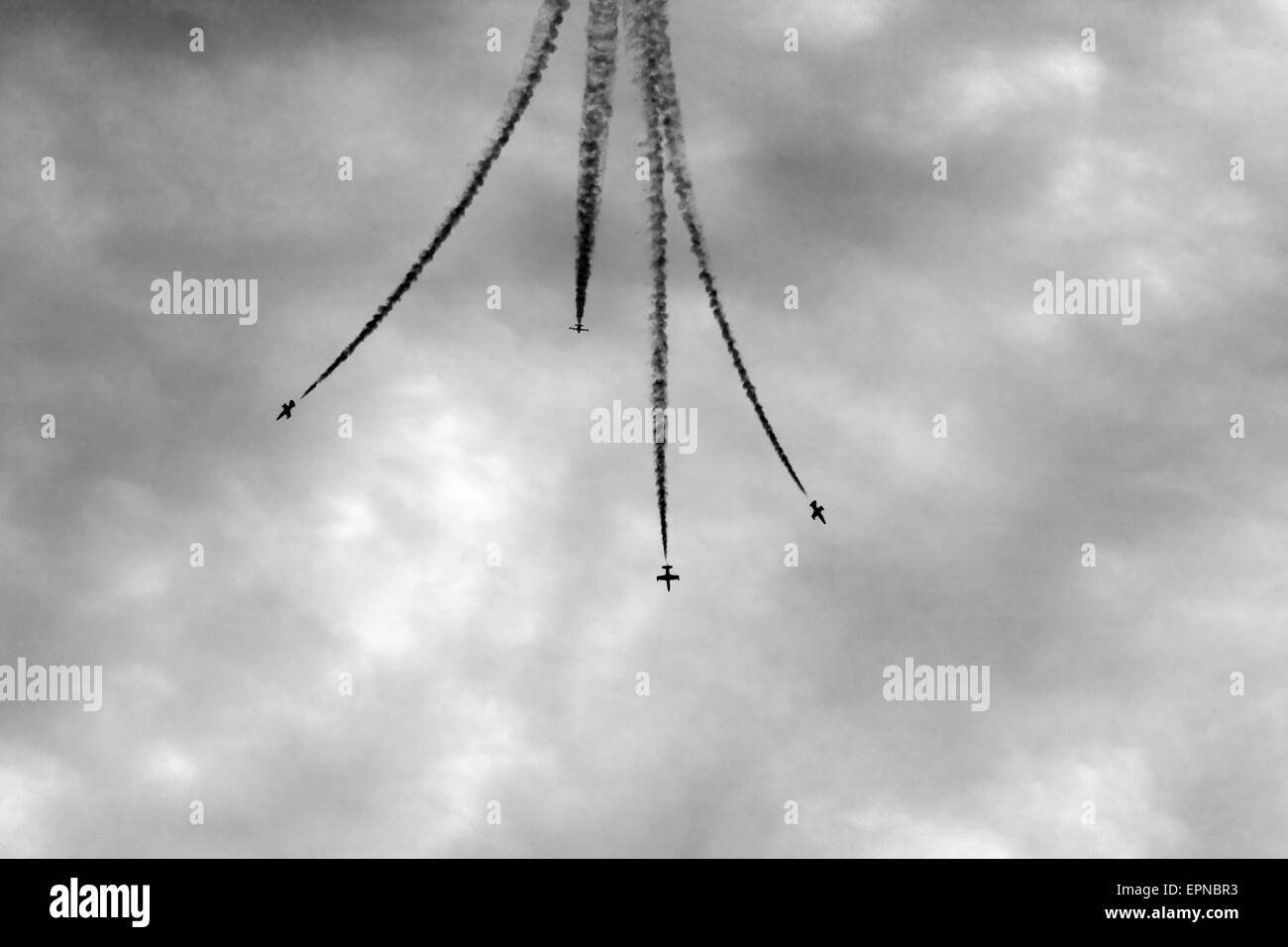 vier Flugzeuge führen synchron Auflösung in den Himmel. Schwarz / weiß Stockfoto