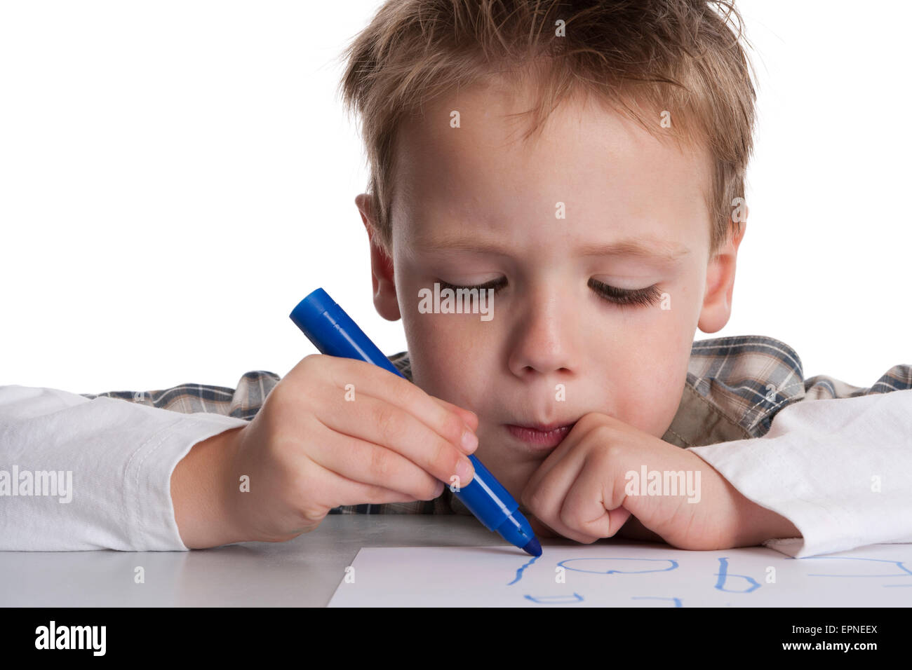 Kleiner Junge macht eine Zeichnung mit einem blauen Filzstift auf weißem Papier Stockfoto