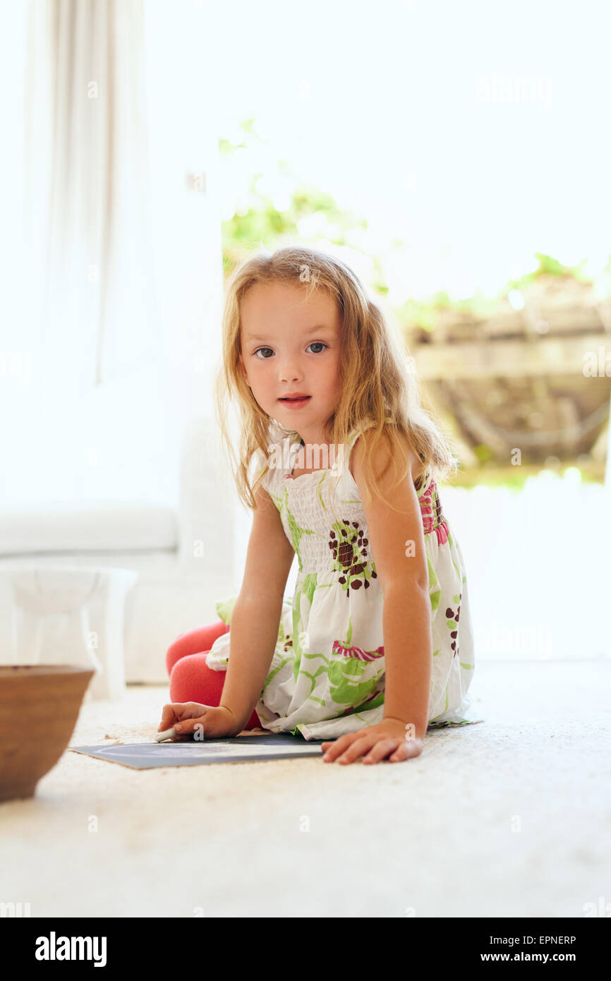 Porträt der niedliche kleine Mädchen sitzend auf Stock zu Hause zeichnen Blick in die Kamera. Grundschulkind junges Mädchen sitzen in livi Stockfoto