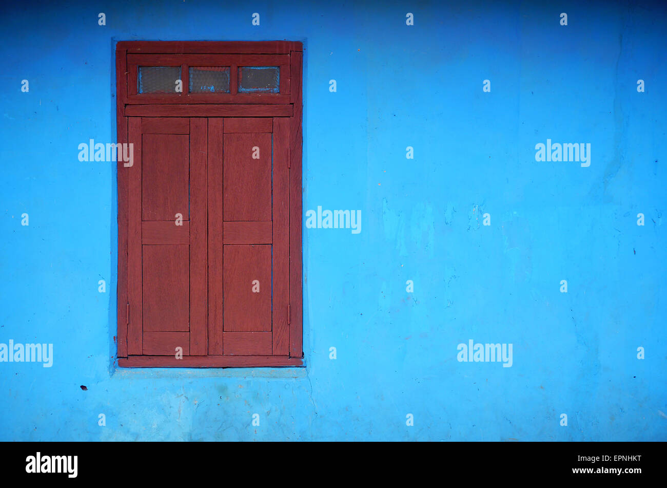roten Fensterläden Fenster und helle blaue Wand Stockfoto
