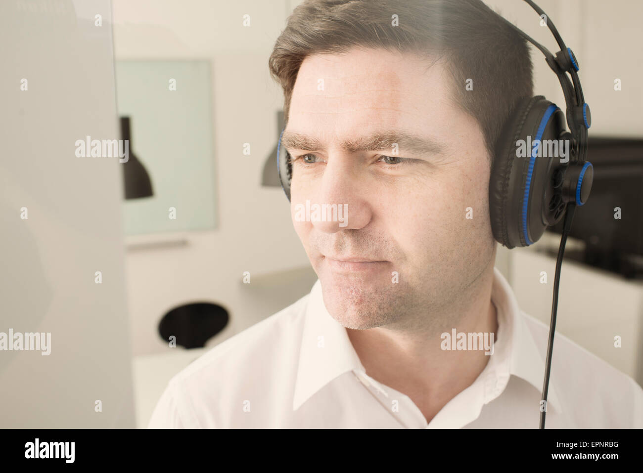 Mann mit Kopfhörer im Büro Musik hören. Stockfoto