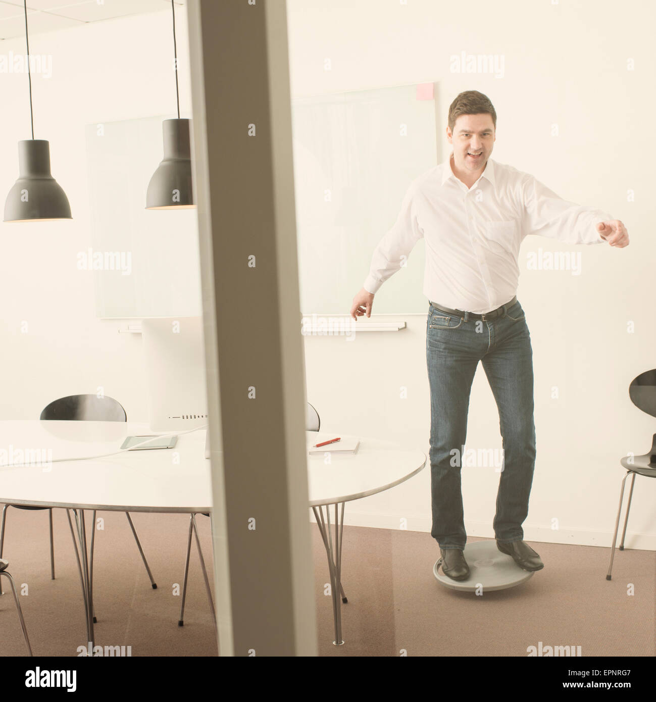Lässige Geschäftsmann im Büro balancieren auf einem Balance-Board. Ein Spaß von der Arbeit zu brechen. Stockfoto