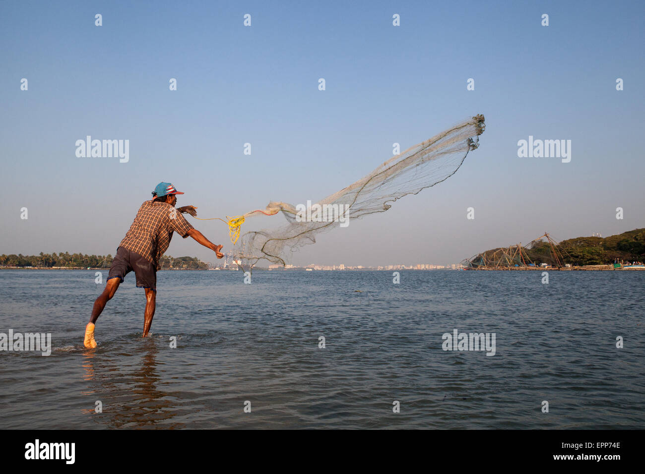 Fischer wirft sein Netz ins Meer in Fort Cochin in Kerala Stockfoto
