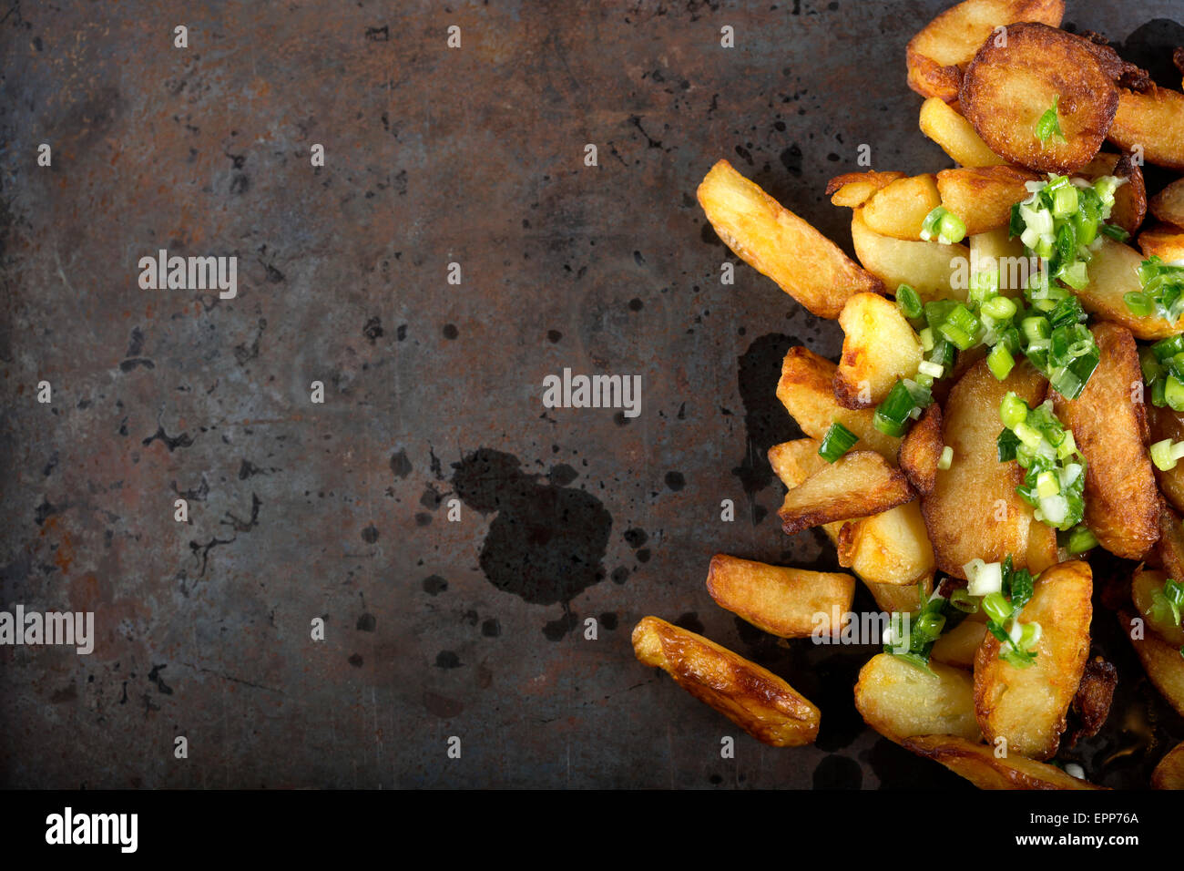 Frische hausgemachte knusprig gebratene Kartoffel Wedges mit grünem Knoblauch - Textfreiraum Stockfoto