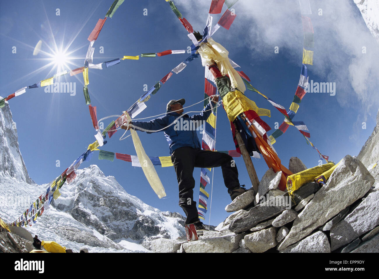 Ein Sherpa hinzufügen den letzten Schliff der Puja, einer traditionellen Zeremonie, der Berg der Götter für ein sicheres Geleit für Clim zu beschwichtigen Stockfoto