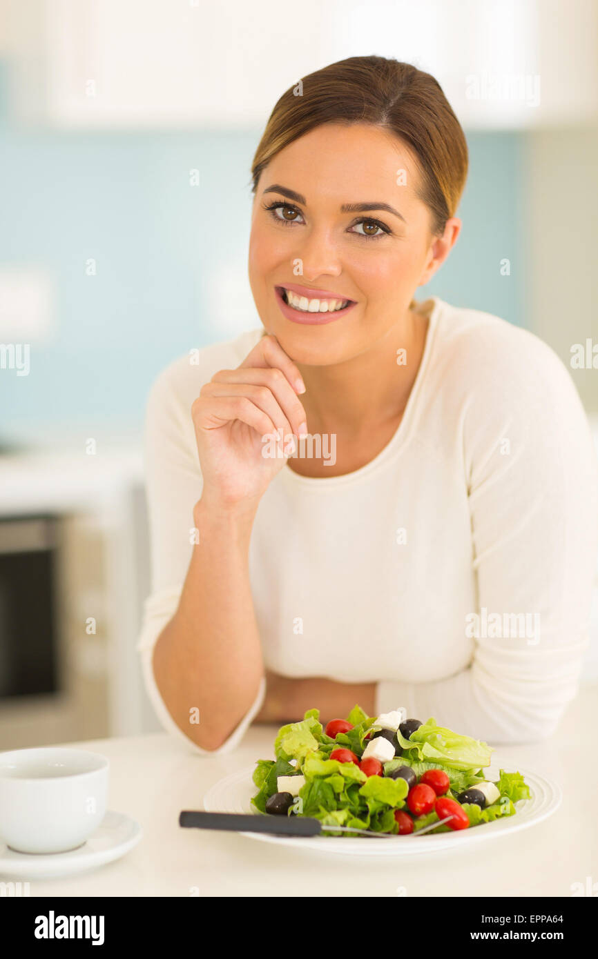 attraktive Frau mit grünem Salat in Küche Stockfoto