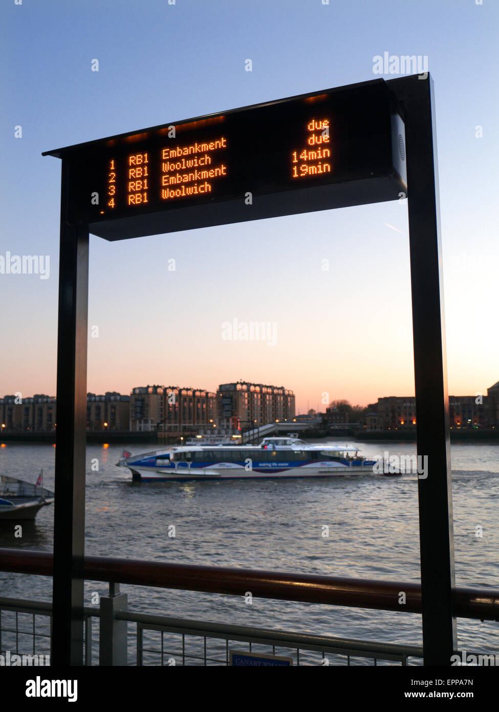 RIVER BOAT RB 1 Ankünfte Informationen Bildschirm und RB1 Thames Clipper Bootstour bei Sonnenuntergang am Canary Wharf London UK anreisen Stockfoto