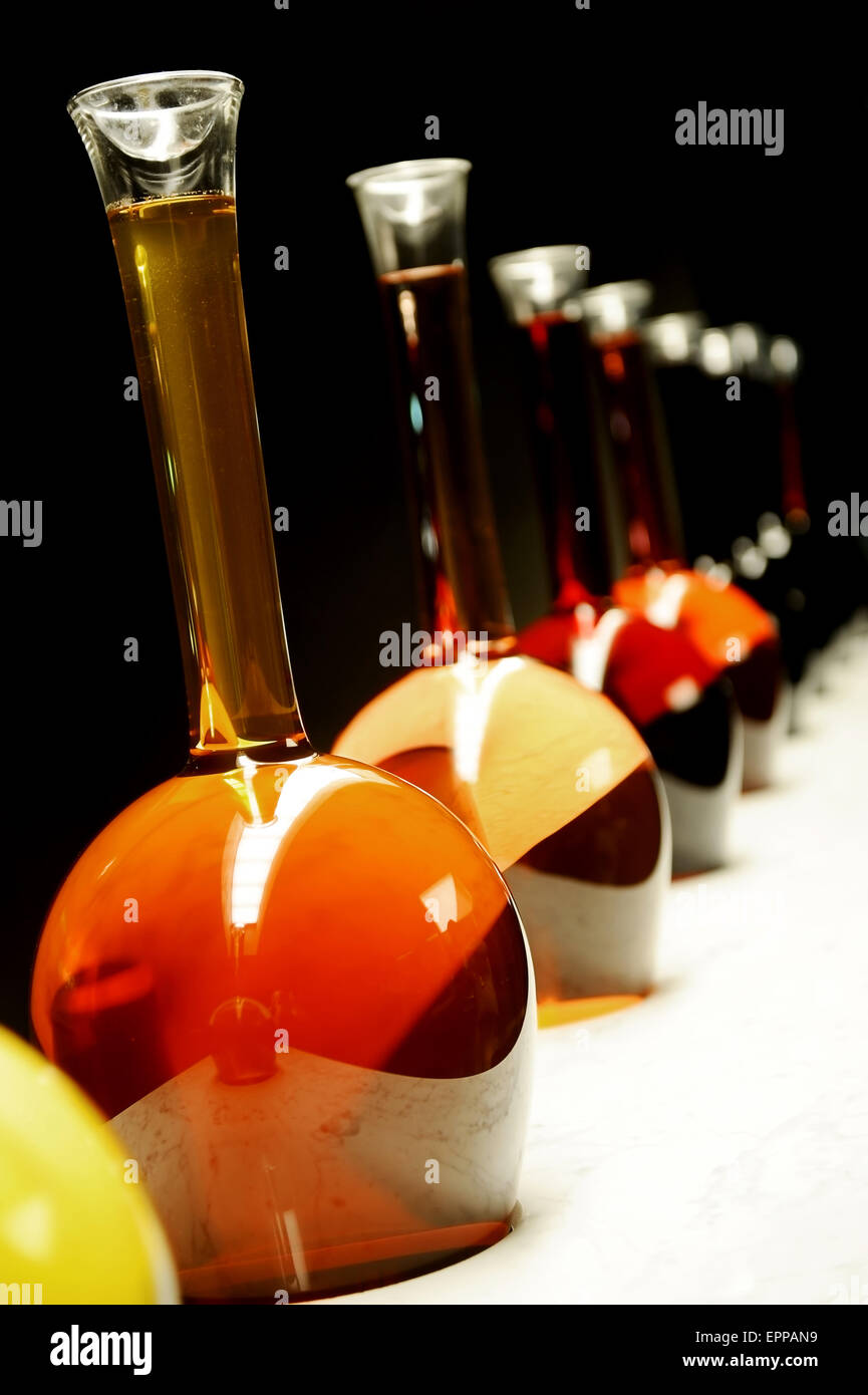 Verschiedene Farben und Arten von Wein in großen Spezialflaschen auf schwarzem Hintergrund Stockfoto
