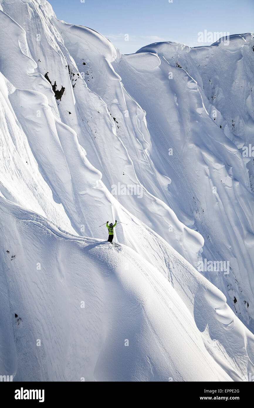 Ein Mann stehen auf einem großen Berg in Haines, Alaska und freuen uns darauf vorbereiten, ski Stockfoto
