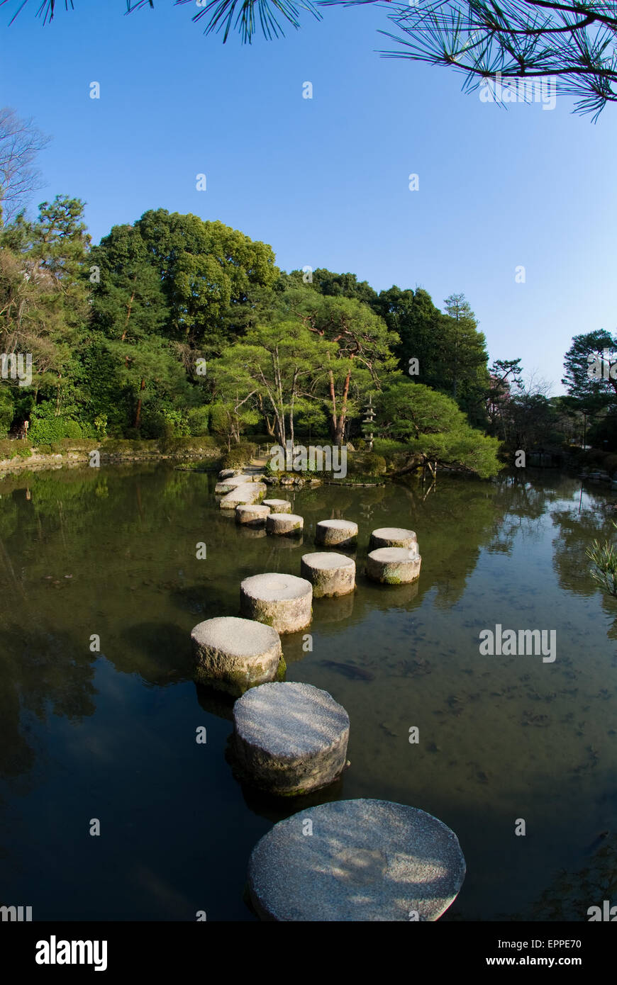 Steinweg über das Wasser auf einem Teich in Kyoto Japan Kiefern und