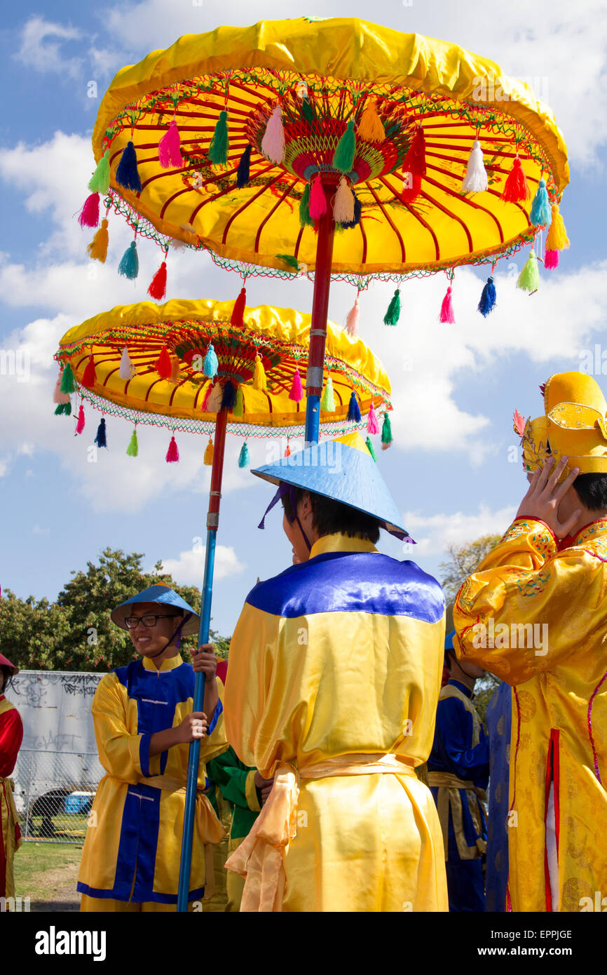 Rollenspieler tragen große Sonnenschirme um den König und die Königin während Tet Festival vor Sonne schützen Stockfoto