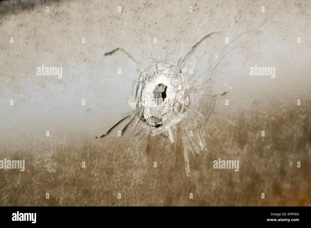 Einschussloch nach einer Waffe Angriff auf ein Haus in einem Fenster links Stockfoto