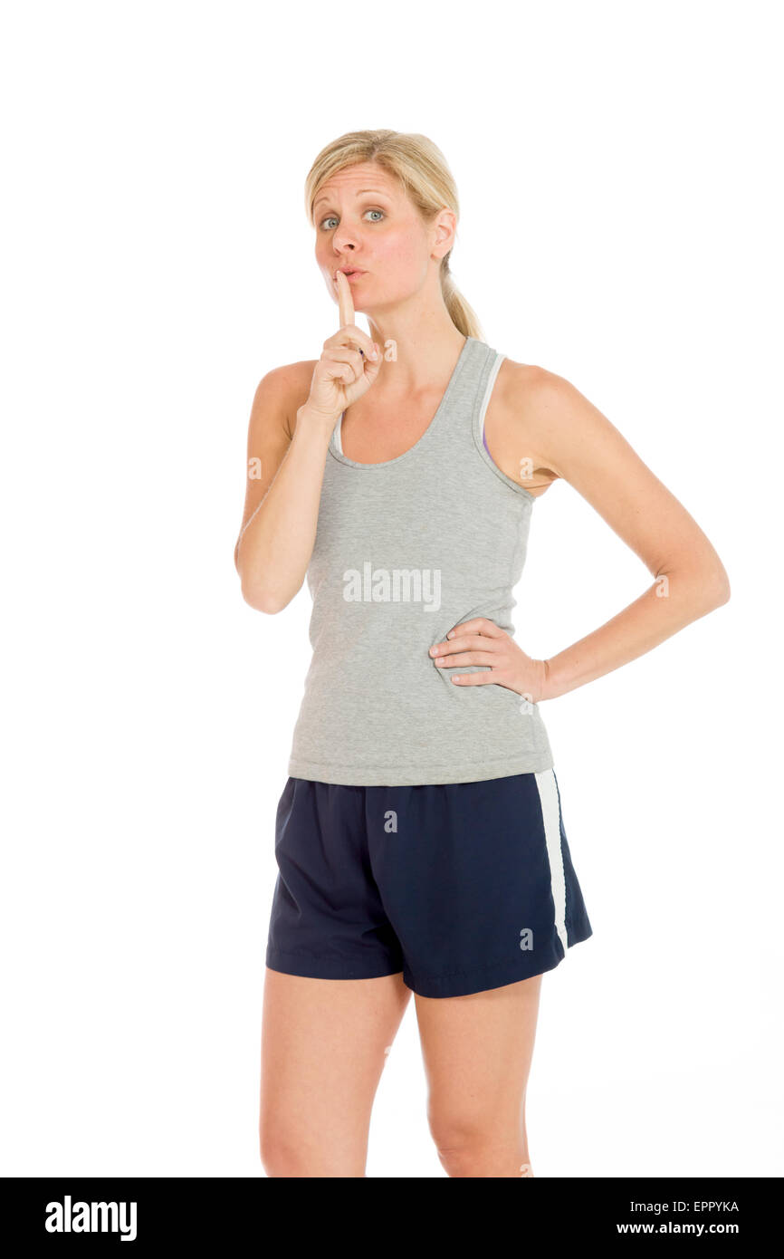 Modell auf einfarbigen Hintergrund im Studio Finger auf die Lippen mit geheimen isoliert Stockfoto