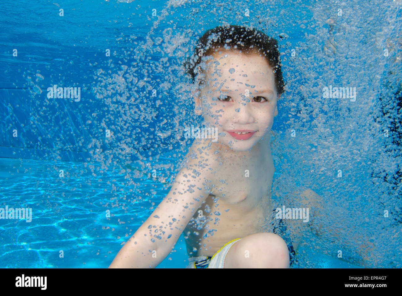 Kleiner Junge hält ihr Atem unter Wasser schweben Stockfoto