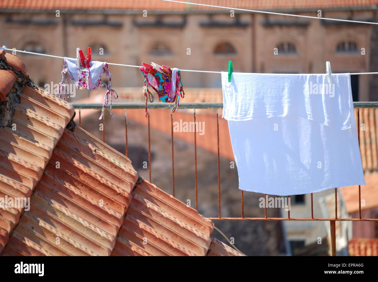 Bikini und Handtuch zum Trocknen auf dem Dach Wäscheleine Stockfoto