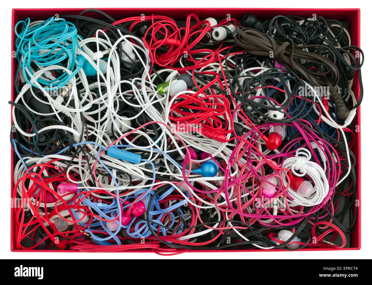 Viele mehrfarbige Massenproduktion moderne Kopfhörer liegt in einem roten Karton. Ansicht von oben.  Isoliert Stockfoto